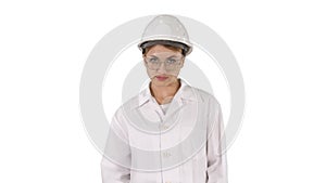 Young woman engineer in hard hat walking on white background.