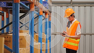 Young woman engineer using digital tablet checking stock in industrial warehouse