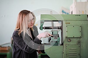 Young woman engineer working at machine tool