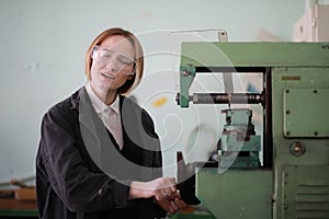 Young woman engineer working at machine tool