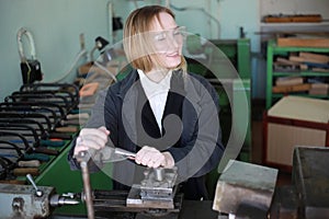 Young woman engineer working at machine tool