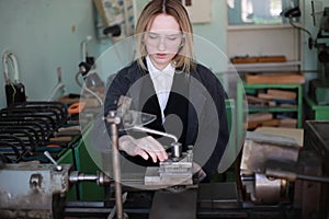 Young woman engineer working at machine tool