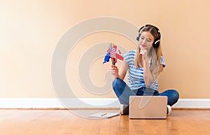 Young woman with English speaking country flags using a laptop