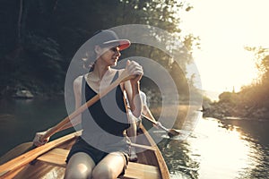 Young woman enjoy canoeing on a forest lake