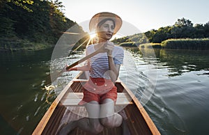 Young woman enjoy canoeing on the sunset lake