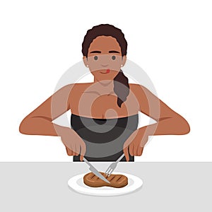 Young woman enjoy eating steak in the dish holding knife and fork as she is ready to eat