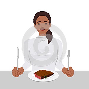Young woman enjoy eating steak in the dish holding knife and fork as she is ready to eat