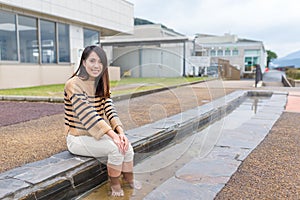 Young Woman enjoy foot onsen with cat at outdoor