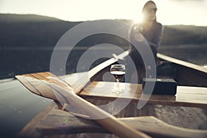 Young woman enjoy outdoors in canoe with glass of red wine