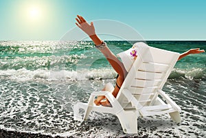 Young woman enjoy a sun on the coast sea