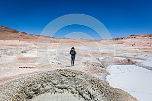 Young woman enjoying the amazing geyser of the Bolivia Altiplano, between Chile and Bolivia, more than 5 thousands meters above th