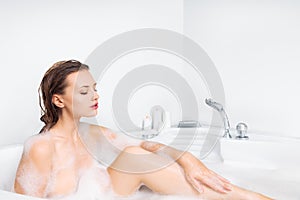 Young woman enjoying bathing in bathtub