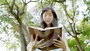 Young Woman Enjoying a Book Reading Outdoors.Concept of recreation, education and study , curiosity, leisure time