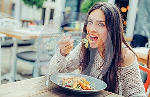 Young woman enjoying food in a restaurant, having her lunch break