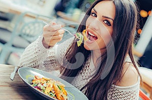 Young woman enjoying food in a restaurant, having her lunch break