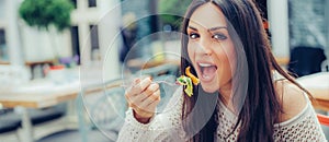 Young woman enjoying food in a restaurant, having her lunch break