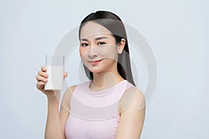 Young woman enjoying a glass of milk isolated over white background
