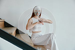 Young woman enjoying home beauty procedure with natural handmade cosmetics