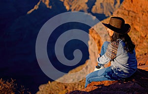 Young woman enjoying the incredibly impressive view over the majestic Grand Canyon