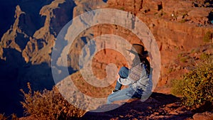 Young woman enjoying the incredibly impressive view over the majestic Grand Canyon