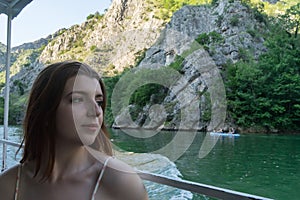 Young woman enjoying a journey in a ship in a lake crossing a river. Red hair White beautiful girl looking to the nature in Matka