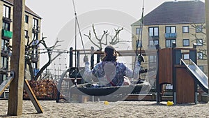 Young woman enjoying outdoor swinging in park, childhood memories, solitude