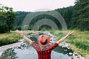 Young woman enjoying the outdoors by the river in the mountains