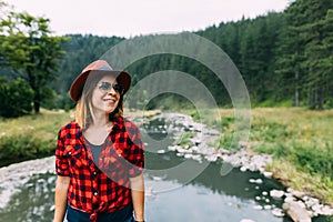 Young woman enjoying the outdoors by the river in the mountains