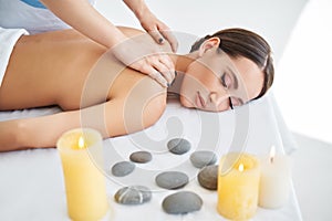 Young woman enjoying relaxing back massage at spa salon