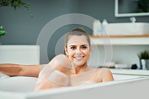 Young woman enjoying and relaxing in the bathtub