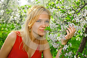 Young woman enjoying smell of blooming tree