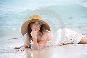 Young woman enjoying summer, laying on beach. Sensual girl sunbathing at sea beach. Summer relax and vacation.