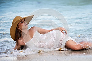 Young woman enjoying summer, laying on beach. Sensual girl sunbathing at sea beach. Summer vacation.
