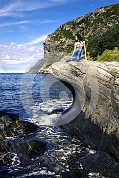 Young woman is enjoying the sunny day on the seaside of Norway