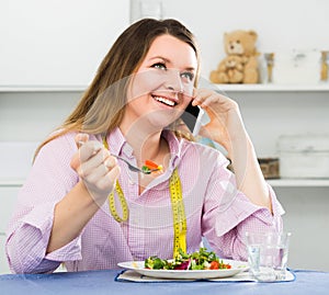 Young woman is enjoying tasty green salad