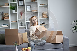 Young Woman Enjoying Unpacking Boxes In New Home photo