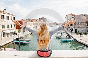 Young woman enjoying the view of the canal in Venice - Italy