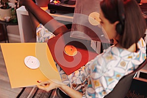 Young woman enjoying vinyl records in cozy room