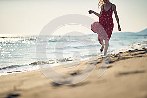 A young woman is enjoying the wind while walking on the beach. Summer, beach, sea, vacation