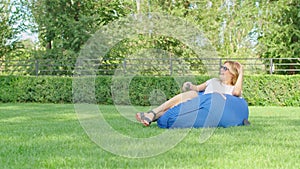 a young woman is enjoying a wonderful cool place in hot summer, having fun, falling on an ottoman, jumping, laughing