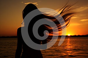 A young woman enjoys the beauty of nature at sunset on the beach, feeling the freedom and relaxation