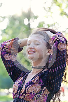 Young woman enjoys sun beams in park photo