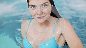 Young woman enjoys water in swimming pool