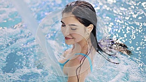 Young woman enjoys water in swimming pool. Aqua aerobics, aquamassage, swimming pool