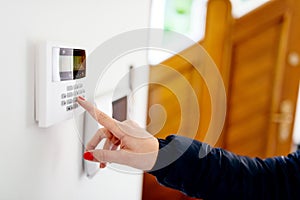 Young woman entering security code on keypad