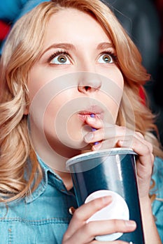 Young woman enthusiastically drinking coke in