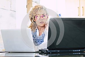 Young woman entrepreneur working on two laptop computer at the desk. Home workplace workstation alternative office for new normal