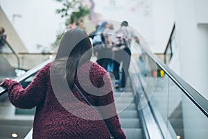 Young woman on escalator in mall