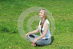 Young woman of European appearance does yoga in summer nature