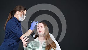 A young woman is examined by a professional trichologist. Treatment of hair loss in a clinic.